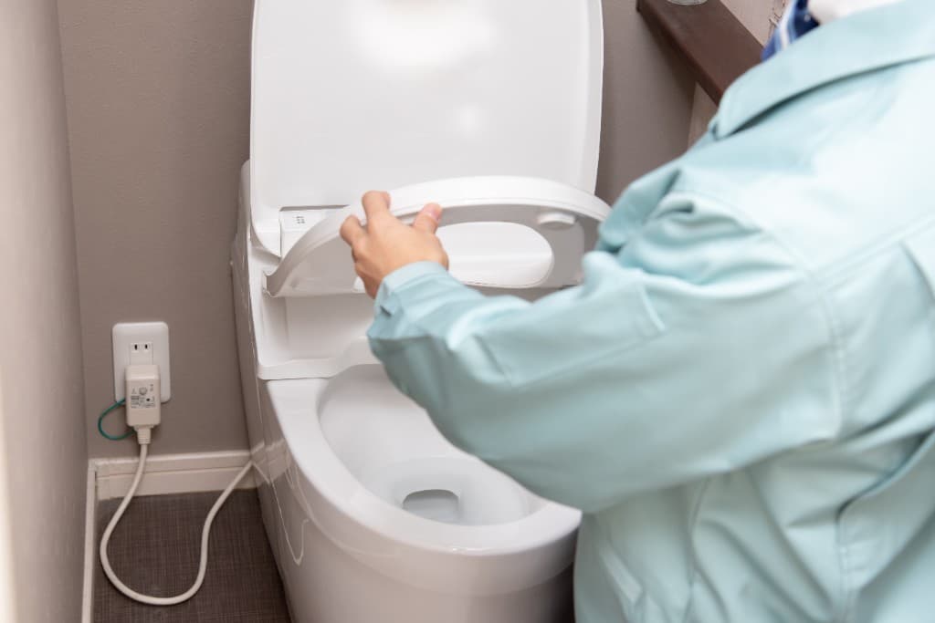 トイレの設備を確認するスタッフ